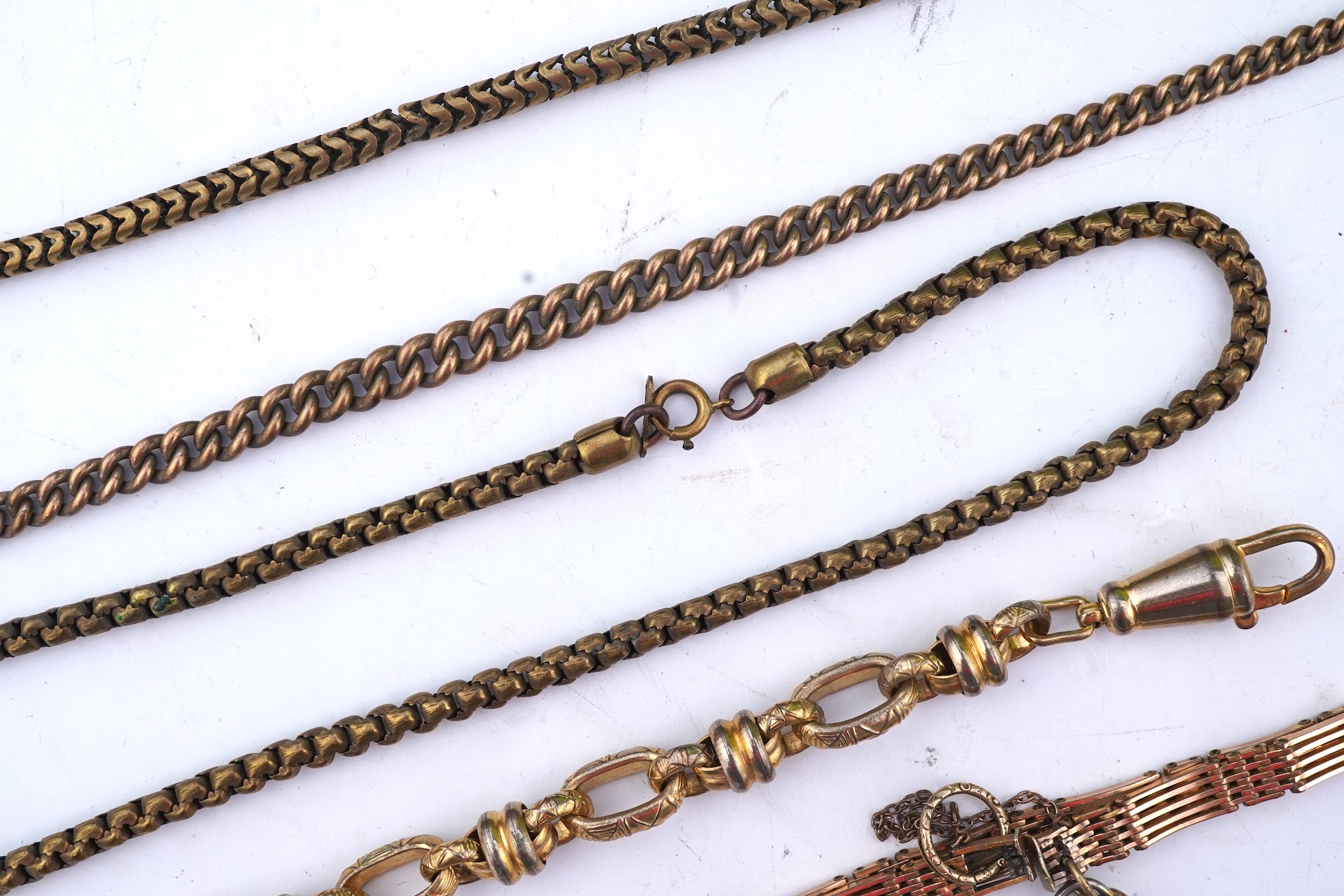A group of gilt metal/pinchbeck jewels, 19th and early 20th century, comprising: a brooch of knotted design; two gate bracelets; a fancy link bracelet; an open-faced pocket watch; two oval panel brooches, and two watch c
